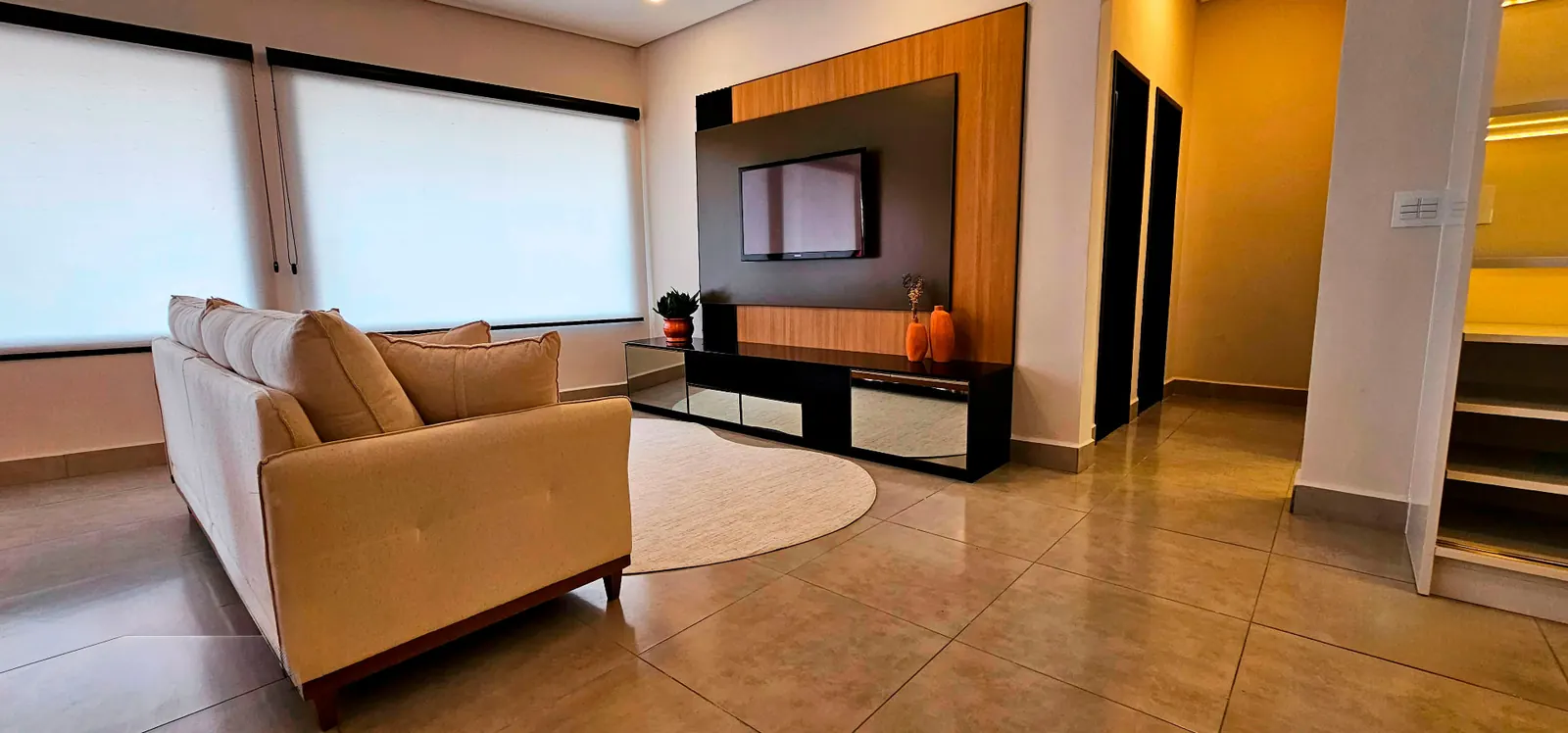 Sala de estar com painel de TV e rack sob medida
