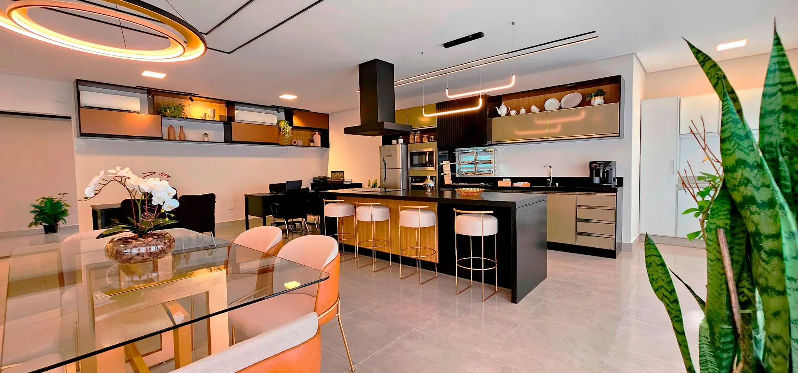 Área gourmet integrada com ilha, banquetas e mesa de jantar
