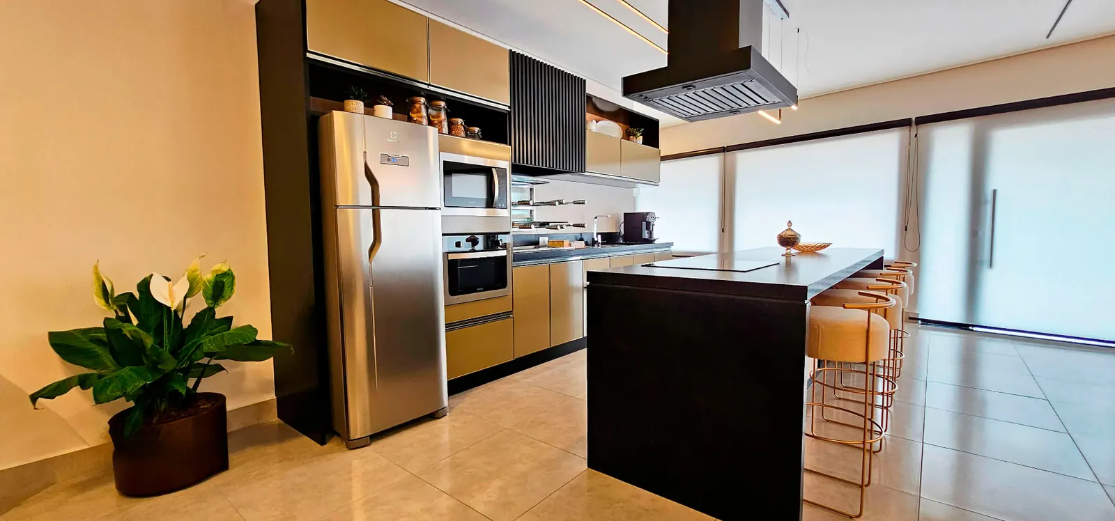 Cozinha planejada em alumínio com torre de embutidos e ilha preta